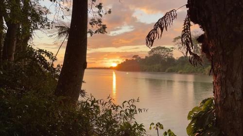 una puesta de sol sobre un río con la puesta de sol en Rio Lindo Hotel, en Dominical