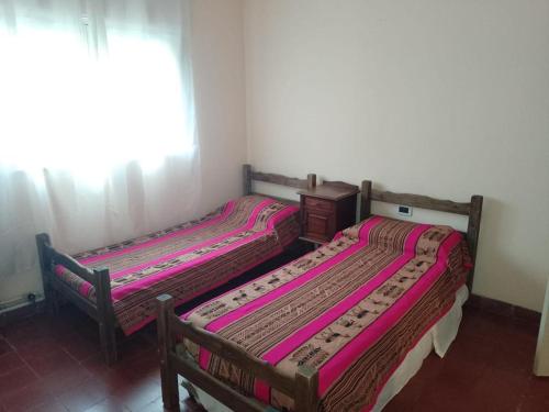 two beds sitting next to each other in a room at Chalet cuesta blanca in Villa Icho Cruz