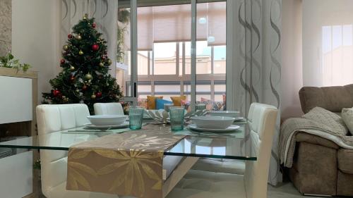 a dining table with a christmas tree in a living room at Apartamento Parquesol in Antequera