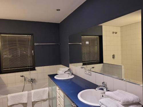 La salle de bains est pourvue de 2 lavabos et d'un grand miroir. dans l'établissement Les Roses de François, à Vaux-sur-Sûre
