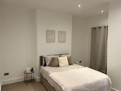 een witte slaapkamer met een bed en een douche bij Tranquil Relaxing 2 Bed Apartment In Peterborough in Peterborough