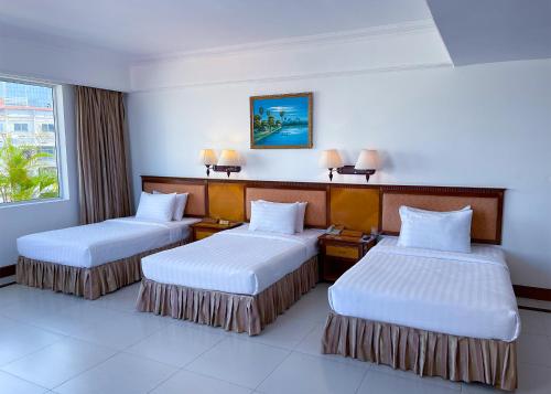 a hotel room with two beds and a window at Hotel Sor in Phnom Penh