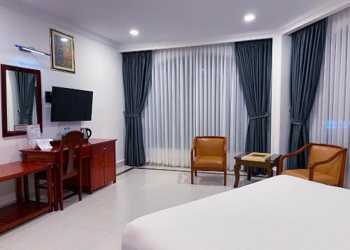 a hotel room with a desk and a bed and a computer at Hotel Sor in Phnom Penh
