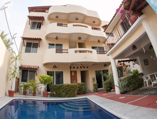 a house with a swimming pool in front of it at Canto del Mar Hotel - Zihuatanejo - Suites con Cocina in Zihuatanejo