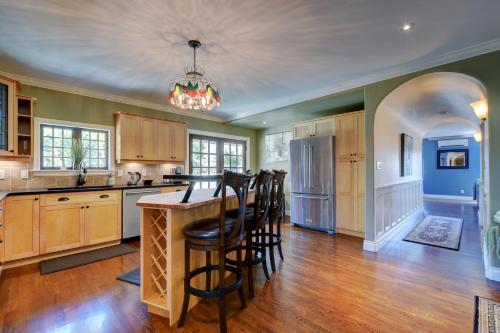 a kitchen with wooden cabinets and a island with bar stools at Character Stay across Swan Lake Nature Sanctuary in Victoria
