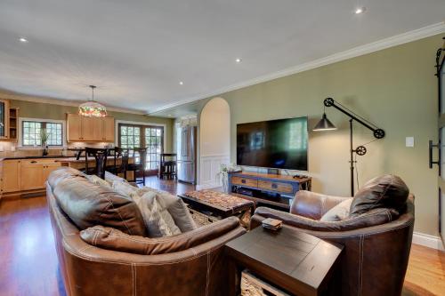 a living room with two leather couches at Character Stay across Swan Lake Nature Sanctuary in Victoria