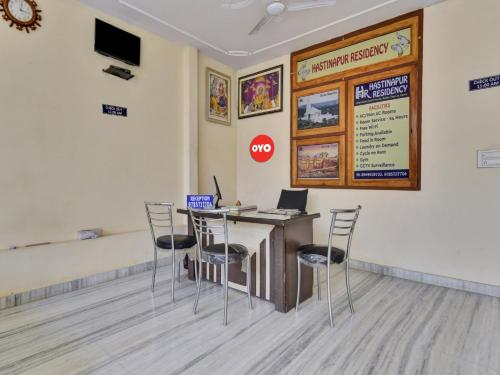 a room with a table with chairs and a laptop at OYO Flagship Hotel Hastinapur Residency in Jaipur