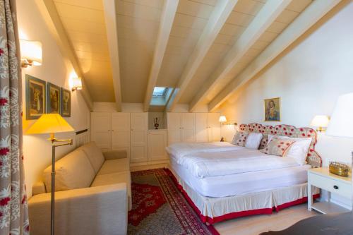 a bedroom with a bed and a couch at White Pine Lodge Livigno in Livigno