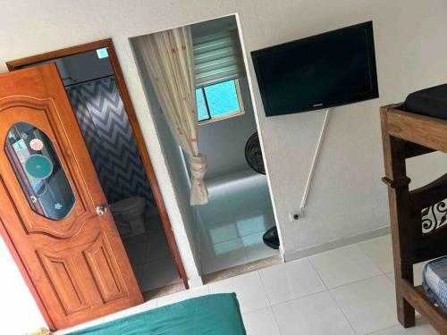 a room with a door and a television in a room at HOSPEDAJE FAMILAR CAMPESTRE "Villa Alondra" in Villavicencio