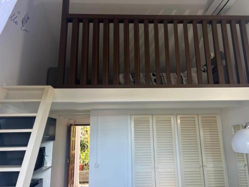 a loft bed in a room with a staircase at Duplex Marina gosier- vue Mer et bateaux in Le Gosier