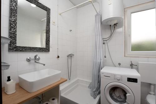 uma casa de banho com uma máquina de lavar roupa e um lavatório em Apartments and rooms by the sea Grebastica, Sibenik - 13942 em Grebaštica