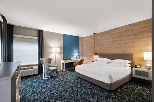 a hotel room with a bed and a desk at Four Points by Sheraton Plano in Plano