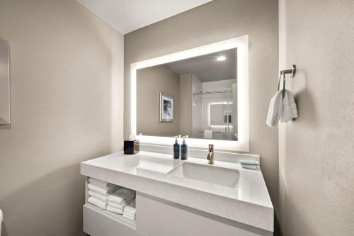 a bathroom with a sink and a mirror at Four Points by Sheraton Plano in Plano