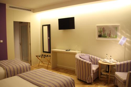 a hotel room with two beds and a table and chairs at Hotel Rural Misarela in Geres