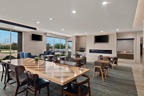 a dining room with tables and chairs and a fireplace at Four Points by Sheraton Plano in Plano