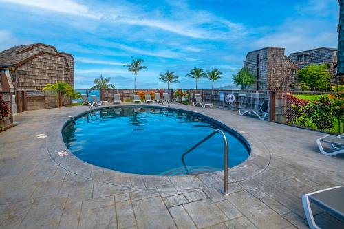 a large swimming pool on a patio at Sealodge E6 - Direct oceanfront views to Kilauea lighthouse! in Princeville