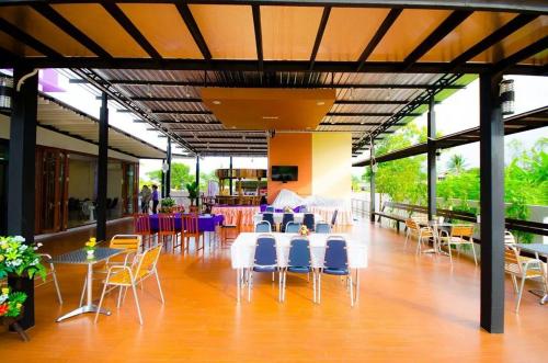 un groupe de chaises et de tables dans un bâtiment dans l'établissement FIG Boutique Hotel, à Kamphaeng Phet