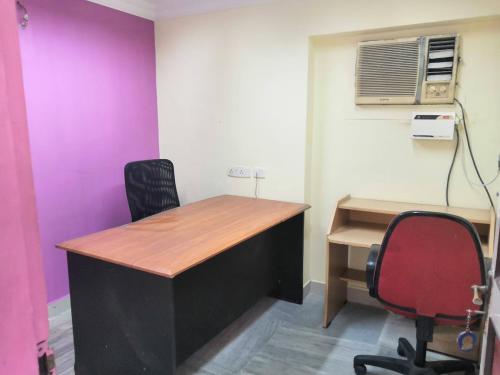 una oficina con escritorio, silla y ventilador en WISHTREE DORMITORY/CORPORATE DORMITORY FOR TECHIES AND TRAINEES, en Chennai