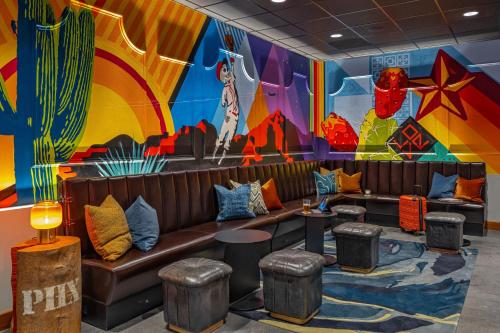 a room with a couch and a colorful mural at Moxy Phoenix Downtown in Phoenix