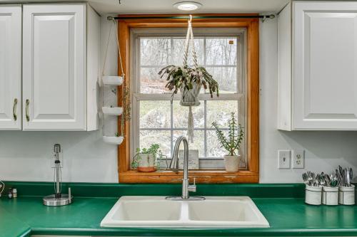 um balcão de cozinha com um lavatório e uma janela em Spencer Getaway with Deck Less Than 1 Mi to Hiking! em Newfield