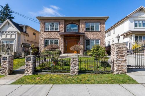 a house with a wrought iron fence in front at An Yang House in Burnaby