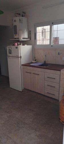 a kitchen with a white refrigerator and a sink at Sol y mar in Balneario Claromecó