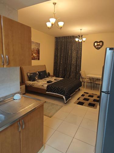 a living room with a bed and a kitchen at Sea View Studio in Ajman