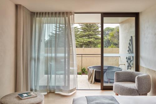 a bedroom with a balcony with a table and a chair at Hotel Sorrento in Sorrento