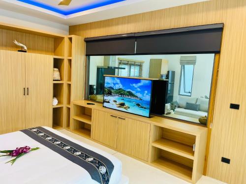 a bedroom with a large window with a flat screen tv at Yuka residence in Koh Samui 