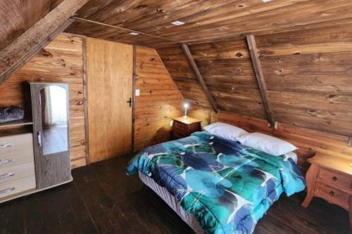a bedroom with a bed in a wooden cabin at Cabañas La Mano Puimayen Cabaña Grande l Reserva con Seña in Barra del Chuy