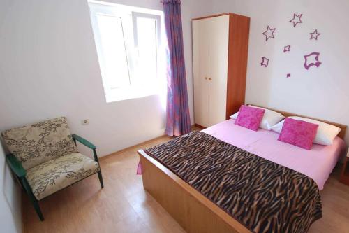 ein Schlafzimmer mit einem Bett, einem Stuhl und einem Fenster in der Unterkunft Apartments with a parking space Njivice, Krk - 21773 in Njivice