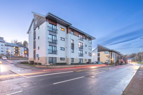 a tall white building on a city street at Luxurious Scottish Apartment in Perth