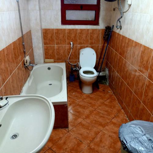 La salle de bains est pourvue de toilettes et d'une baignoire. dans l'établissement بيت الطالبات والمغتربات, à Ville du 6 Octobre