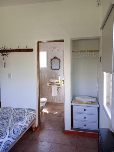 een badkamer met een wastafel, een toilet en een spiegel bij Loft Las Acacias in Potrero de los Funes