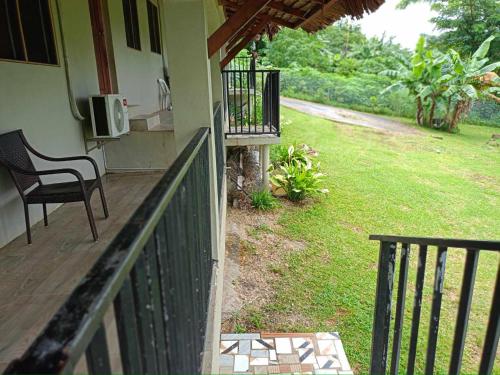 a porch of a house with a chair and a yard at Tias appartment in Port Vila