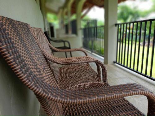 two wicker benches sitting on a porch at Tias appartment in Port Vila