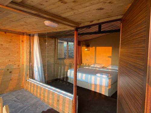 ein Schlafzimmer mit einem Bett in einem Holzzimmer in der Unterkunft Dana’s Trail Hotel in Dana