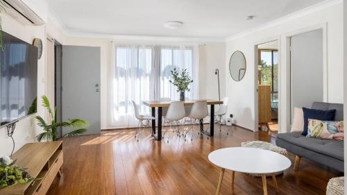 a living room with a table and a couch at Walking Distance to Shoal Bay Beach in Shoal Bay