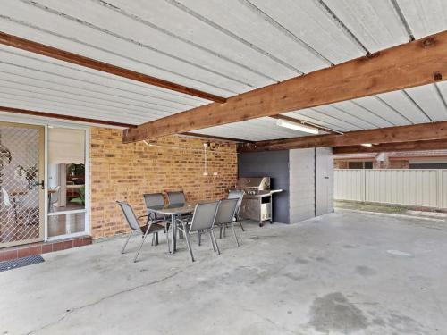 a patio with a table and chairs on it at Walking Distance to Shoal Bay Beach in Shoal Bay