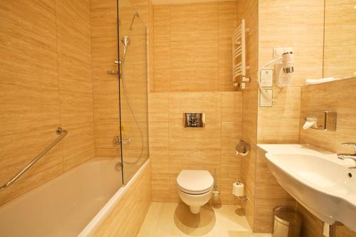 a bathroom with a toilet and a sink and a shower at Holiday Inn Łódź by IHG in Łódź