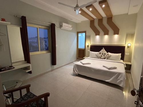 a bedroom with a large white bed and some windows at Max Guest House in Agra