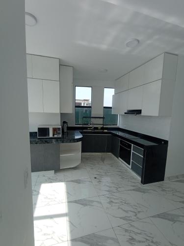 a large kitchen with white cabinets and black counter tops at Alquilo Casa playa in San Antonio