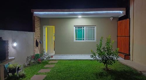 ein Haus mit einem grünen Hof mit gelber Tür in der Unterkunft Dpto LUDIM in Federación