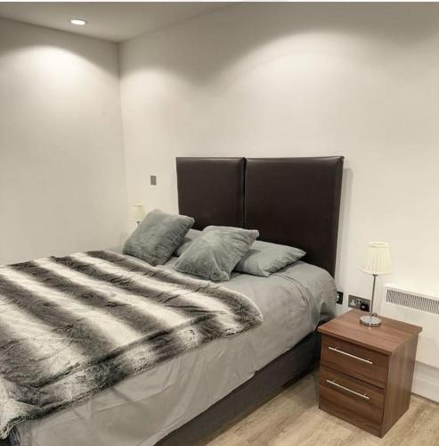 1 dormitorio con 1 cama grande y mesita de noche en Mediacity studio apartment Salford-quays, en Mánchester