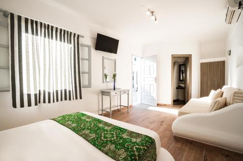 1 dormitorio con 2 camas y sala de estar en Villa Iliovasilema Santorini, en Akrotiri