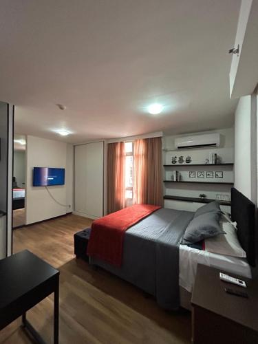 a bedroom with a large bed and a television at Flat em Brasília - Park Sul in Brasília