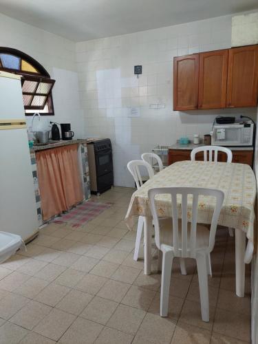 a kitchen with a table and chairs in it at Ótima casa Rio das Ostras in Rio das Ostras