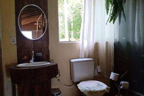La salle de bains est pourvue d'un lavabo, d'un miroir et d'une fenêtre. dans l'établissement Casa rústica pertinho das águas, à Santo Amaro da Imperatriz