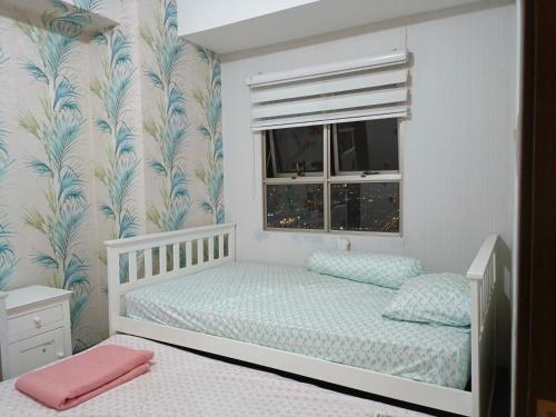 1 Schlafzimmer mit 2 Betten und einem Fenster in der Unterkunft Apartemen Syariah Bandung Banget in Bandung