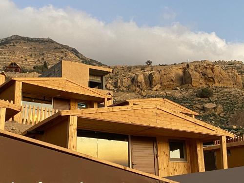 Dana’s Trail Hotel في دانا: يتم بناء منزل مع جبل في الخلفية